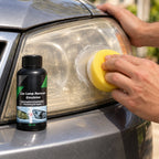 Hand working the yellow sponge over a car headlight with the Lensmith bottle beside it